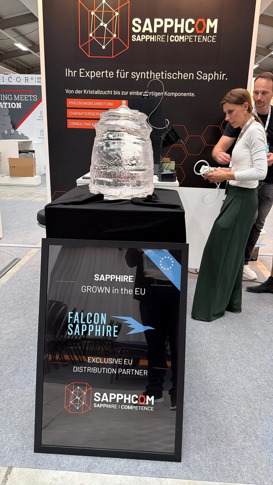 Saphirkristall am SAPPHCOM-Messestand mit Hinweis auf die EU-Partnerschaft mit Falcon Sapphire